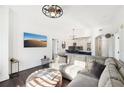 Bright living room with a gray sectional sofa, an ottoman, and dark hardwood floors at 2277 Peachtree Ne Rd # 405, Atlanta, GA 30309