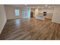 Open-concept kitchen and living area with wood-look flooring at 771 Gelderland Dr, Hampton, GA 30228