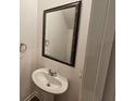 Small bathroom with pedestal sink and framed mirror at 771 Gelderland Dr, Hampton, GA 30228