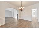 Formal dining room with hardwood floors, chandelier, and wainscoting at 5506 Sara Creek Ln, Sugar Hill, GA 30518