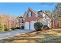 Side view of a brick house with a three-car garage at 5506 Sara Creek Ln, Sugar Hill, GA 30518