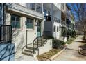 Street view of new construction townhomes featuring individual entry stairs and well-maintained landscaping at 711 Needletail Way, Atlanta, GA 30312