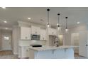 Modern kitchen with white cabinets, quartz countertops, and a large island at 163 Bluffington Way, Marietta, GA 30066