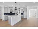 Bright kitchen features a spacious island, stainless appliances, and stylish cabinets against hardwood floors at 6210 Misty Hill Ln, Buford, GA 30518