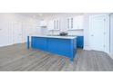 Modern kitchen with blue island, white cabinets, and granite countertops at 1440 Fairview Rd, Ellenwood, GA 30294