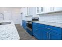 Modern kitchen with blue cabinets and granite countertops at 1440 Fairview Rd, Ellenwood, GA 30294