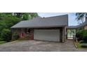Attached two-car garage with brick siding, new roof, and a driveway for ample parking space at 1294 Dogwood Rd, Snellville, GA 30078
