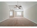 Spacious carpeted bedroom with ceiling fan and large windows at 7110 Ravenwood Ln, Lithonia, GA 30038