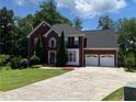 Charming two-story brick home with well-maintained landscaping, two car garage and a spacious driveway at 1886 Clay Sw Dr, Marietta, GA 30064
