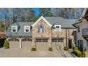 Three-car garage with gray doors and stone exterior at 571 Glen Eagles Se Cir, Marietta, GA 30067