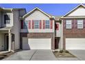 Townhome featuring light siding, brick accents, red shutters and an attached garage at 177 Oakland Hills Way, Lawrenceville, GA 30044