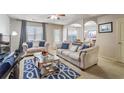 Comfortable living room featuring neutral decor, two sofas, a ceiling fan, and a decorative blue rug at 177 Oakland Hills Way, Lawrenceville, GA 30044