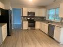 Modern kitchen with white cabinets, granite countertops, and stainless steel appliances at 3730 Oak Park Dr, Suwanee, GA 30024