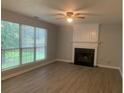 Living room with fireplace and large windows overlooking backyard at 3730 Oak Park Dr, Suwanee, GA 30024