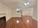 Open living room with hardwood floors, a fireplace, and kitchen views at 713 Cypress Pointe St, Alpharetta, GA 30022