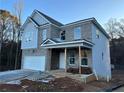 Two-story house with gray siding and brick accents, attached garage, and covered porch at 566 Abbott Se Ct, Atlanta, GA 30354