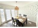 Charming dining room with a wooden table, four chairs, and a wicker pendant light at 6980 Roswell Rd # E1, Sandy Springs, GA 30328