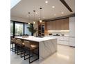 Modern kitchen featuring a large island with marble countertops, pendant lighting, and sleek cabinetry at 7512 Rivertown Rd, Fairburn, GA 30213