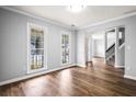 Bright living room featuring hardwood floors, white trim, and abundant natural light from the large windows at 125 Cinnamon Fern Cir, Covington, GA 30016