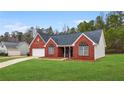 Red brick house with gray roof, attached garage, and a spacious yard at 435 Berkshire Dr, Covington, GA 30016