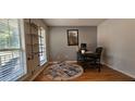 Bright home office with ample natural light, hardwood floors, and a unique industrial-style shelving unit at 553 Stonemill Mnr, Lithonia, GA 30058