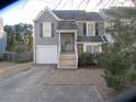 Two-story house featuring gray siding, a white garage door, and a brick base at 390 Lakeridge Ct, Riverdale, GA 30274