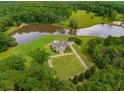 Aerial view showcasing a home's serene setting near a lake at 833 Hines Rd, Moreland, GA 30259
