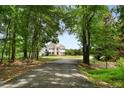 Long driveway leading to a beautiful home nestled among lush trees at 833 Hines Rd, Moreland, GA 30259