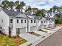 Row of townhouses with gray siding, attached garages, and landscaped yards at 5435 Rock Place Ct # 38, Norcross, GA 30093