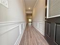 Inviting hallway with elegant wainscoting, crown molding, and durable wood-look flooring at 5435 Rock Place Ct # 38, Norcross, GA 30093