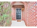 Black front door with arched entryway and brick facade at 2942 War Party Ct, Douglasville, GA 30135