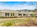 Beautifully maintained home with a green lawn, mature trees, white siding and black shutters at 850 Thurman Rd, Stockbridge, GA 30281