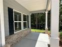 Covered front porch with gray siding, brick base, and white columns at 142 Tye St, Stockbridge, GA 30281