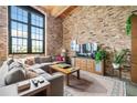 Living room with exposed brick, sectional sofa, and large window at 170 Boulevard Se # H401, Atlanta, GA 30312