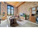 Open living area with exposed brick, kitchen, and large windows at 170 Boulevard Se # H401, Atlanta, GA 30312