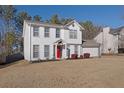 Two-story house with white siding, red door, and attached garage at 3945 Brushy Creek Way, Suwanee, GA 30024