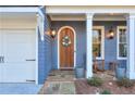 Inviting front porch with a wooden door, stone flooring, and rocking chairs at 1103 Ridenour Ct, Kennesaw, GA 30152