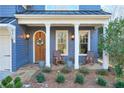 Charming front porch with blue siding, wooden door, and rocking chairs at 1103 Ridenour Ct, Kennesaw, GA 30152