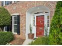 Red front door entryway with brick facade and potted plants at 15 Independence Nw Pl, Atlanta, GA 30318