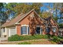 Brick house with a two car garage and mature trees at 170 Amicalola Way, Jonesboro, GA 30236