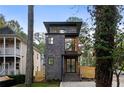 Contemporary three-story home with brick and white siding, and a private driveway at 2870 Daws Se Ave, Atlanta, GA 30317