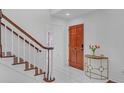 Bright foyer with a staircase, hardwood door, table, and white tile flooring at 218 Forkner Dr # D, Decatur, GA 30030