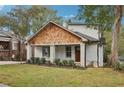 Renovated craftsman bungalow with a white brick exterior, wood accents, and a lush lawn at 458 Holly Nw St, Atlanta, GA 30318