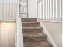 Interior view of carpeted staircase with white railings at 5224 Martins Crossing Rd, Stone Mountain, GA 30088