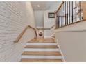 Elegant staircase with light wood steps, white risers, and a white brick wall at 120 Ridgely Ct, Atlanta, GA 30342