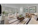 Staged living room featuring new floors, large windows, and stylish furniture at 411 Berkeley Woods Dr, Duluth, GA 30096