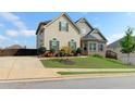 Tan and brick two-story home with attached garage and a landscaped yard at 45 Silver Peak Dr, Covington, GA 30016