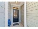 Front entry with black door, light gray siding, and a blue hose at 108 Kasey Dr, Woodstock, GA 30189