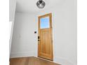 Light and airy entryway with wood floors and modern door at 10861 Serenbe Ln, Chattahoochee Hills, GA 30268