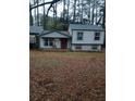 Gray siding home with a red front door and mature trees at 3195 Newcastle Way, Snellville, GA 30039